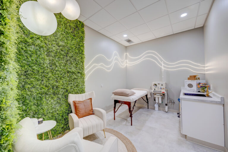 VIVA Wellness colon hydrotherapy room with treatment table, moss wall and illuminated wall detail