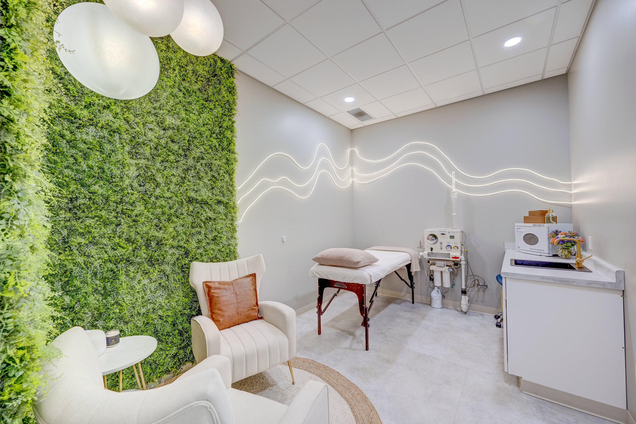 VIVA Wellness colon hydrotherapy room with treatment table, moss wall and illuminated wall detail