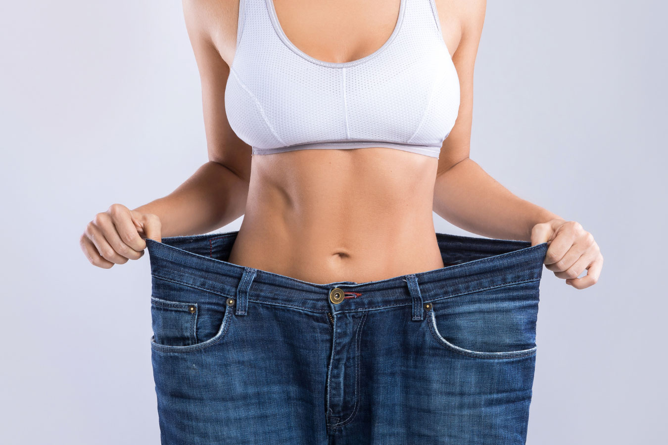 woman holding large pants over waist